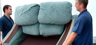 Two employees of Better Call Jon Junk Removal in The Santa Clarita Valley Area, carrying furniture during a junk removal service.